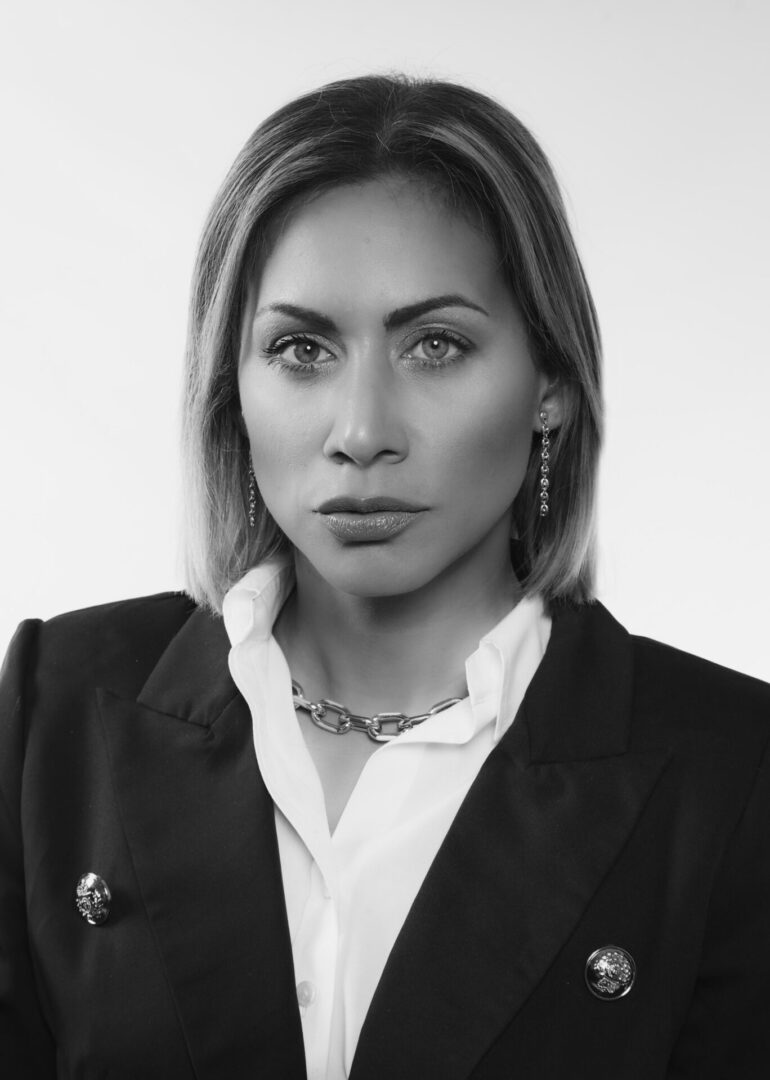 A woman in a suit and necklace.